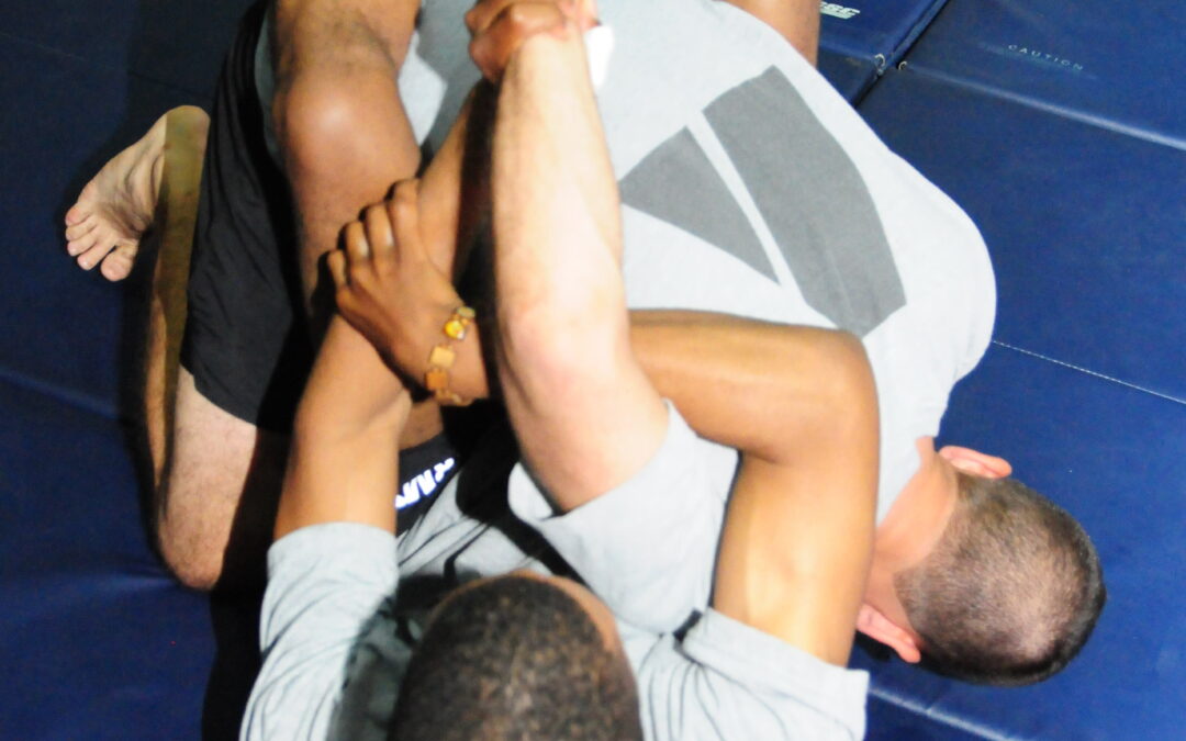 Brazilian Jiu-Jitsu practitioners demonstrating a Kimura lock from guard position
